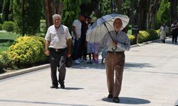 Kavurucu sıcakta şemsiye ve şapkalı önlem
