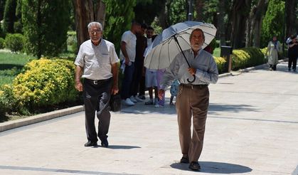 Kavurucu sıcakta şemsiye ve şapkalı önlem