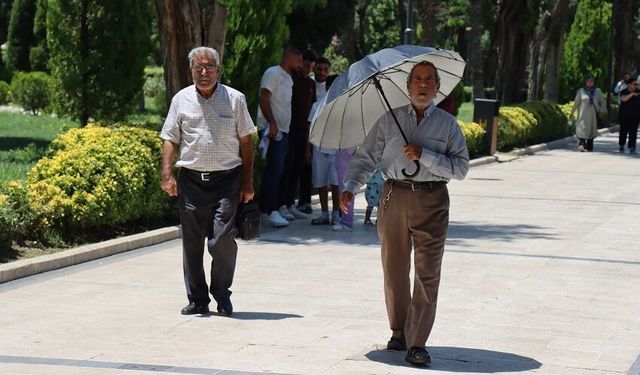 Kavurucu sıcakta şemsiye ve şapkalı önlem